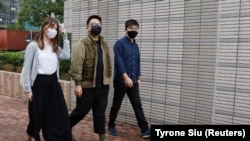 Жошуа Воң (оң жакта) менен кошо дагы эки активист соттолууда, алар да күнөөсүн монга алышты.