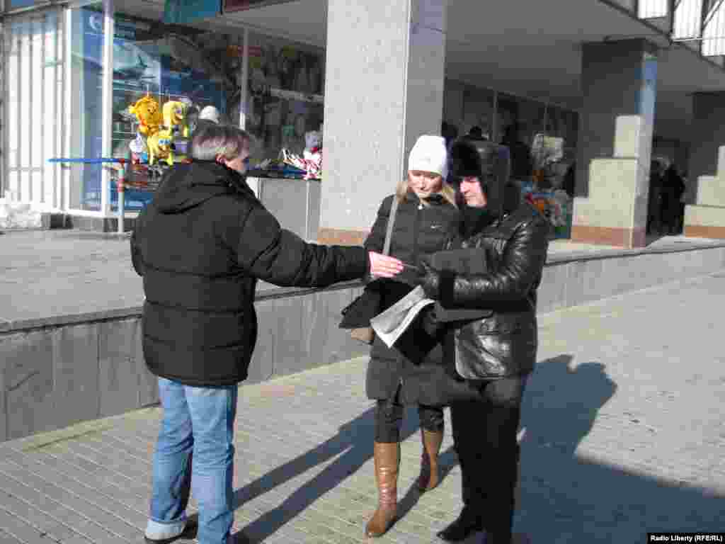 Активист раздает визитки движени 'Белая лента'