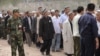 FILE: Ethnic Uighurs, some wearing white flowers, gather before an official ceremony.