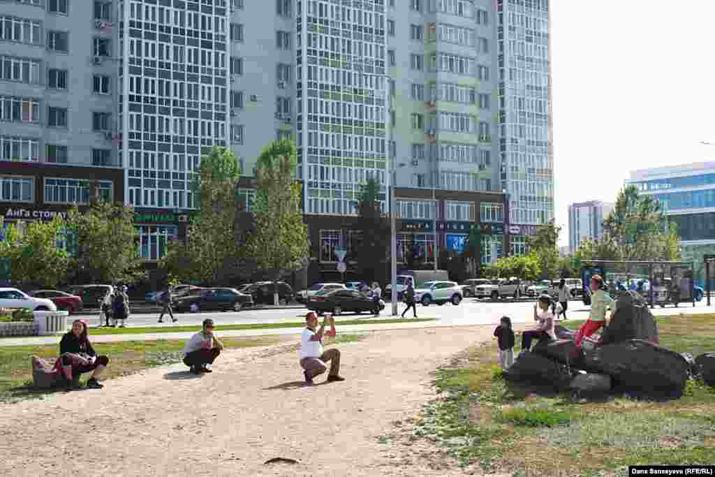 Астанада суретке түсіп жатқан адамдар. 
