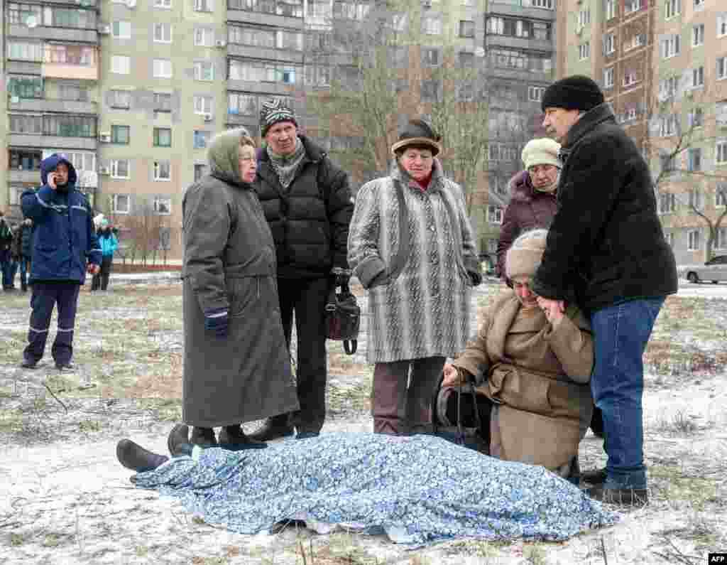 Родичі поряд з тілом загиблої внаслідок обстрілу «Градами» житлового масиву в Краматорську, 10 лютого 2015 року