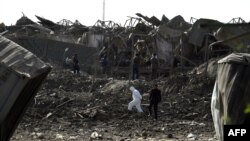 FILE: International and Afghan investigators at the site of a powerful truck bomb blast that targeted a hotel used by foreign contractors in Kabul.