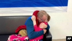 Fetiţă care a fost deţinută ostatică de Hamas, la reîntâlnirea cu tatăl ei, în Israel, duminică.