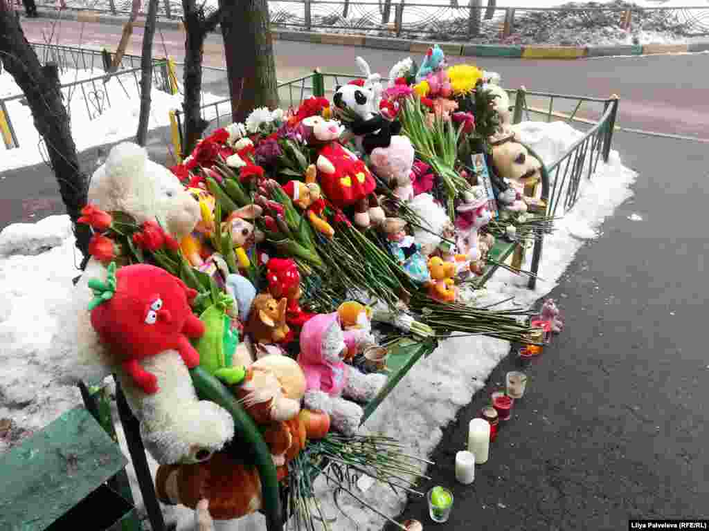 Другой такой же мемориал появился на скамейке у дома, где жила семья, в которой произошла трагедия. 