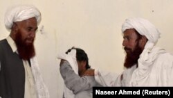 Men mourn the death of relatives and party workers, who were killed in a suicide bombing attack during an election campaign meeting near Quetta, the capital of southwestern Balochistan Province on July 13.