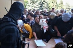 Үй-жайын тастап, елді мекендерден қашуға мәжбүр болған жұрт гуманитарлық көмек алуға кезекте тұр. Ресей, Курск облысы, 14 тамыз, 2024 жыл.