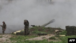 Nagorno-Karabakh -- Armenian servicemen of the self-defense army of Nagorno-Karabakh fire an artillery shell towards Azeri forces from their positions in the town of Martakert , April 3, 2016