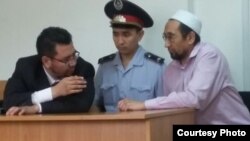Сотталушы Сәкен Тулбаев (оң жақта) адвокаты Жандос Булхайырмен (сол жақта) сөйлесіп тұр. Алматы, 29 маусым 2015 жыл.